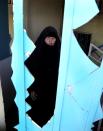 An Iraqi woman inspects the damage to her house in the aftermath of a Monday car bombing in a crowded commercial street in Baghdad's eastern neighborhood of Sadr City, Iraq, Tuesday, April 22, 2014. Suicide bombings and other attacks across Iraq killed and wounded dozens on Monday, officials said, the latest in an uptick in violence as the country counts down to crucial parliamentary elections later this month. (AP Photo/Karim Kadim)