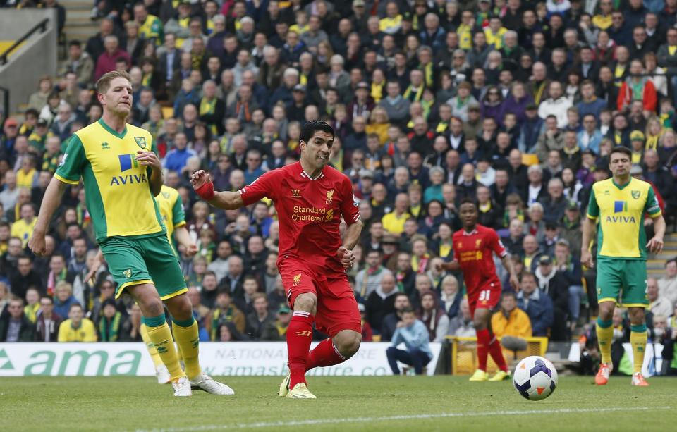 Liverpool's Luis Suarez (2nd L) shoots and scores his goal against Norwich City during their English Premier League soccer match at Carrow Road in Norwich April 20, 2014. REUTERS/Stefan Wermuth (BRITAIN - Tags: SPORT SOCCER) NO USE WITH UNAUTHORIZED AUDIO, VIDEO, DATA, FIXTURE LISTS, CLUB/LEAGUE LOGOS OR "LIVE" SERVICES. ONLINE IN-MATCH USE LIMITED TO 45 IMAGES, NO VIDEO EMULATION. NO USE IN BETTING, GAMES OR SINGLE CLUB/LEAGUE/PLAYER PUBLICATIONS. FOR EDITORIAL USE ONLY. NOT FOR SALE FOR MARKETING OR ADVERTISING CAMPAIGNS