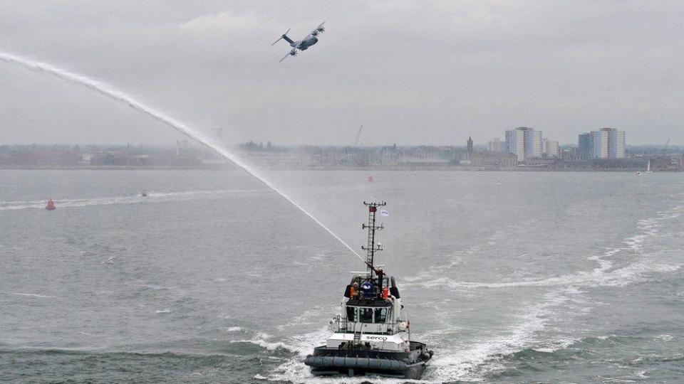 Flypast by an RAF A400 and tugboat spraying water as ferry with veterans left Portsmouth