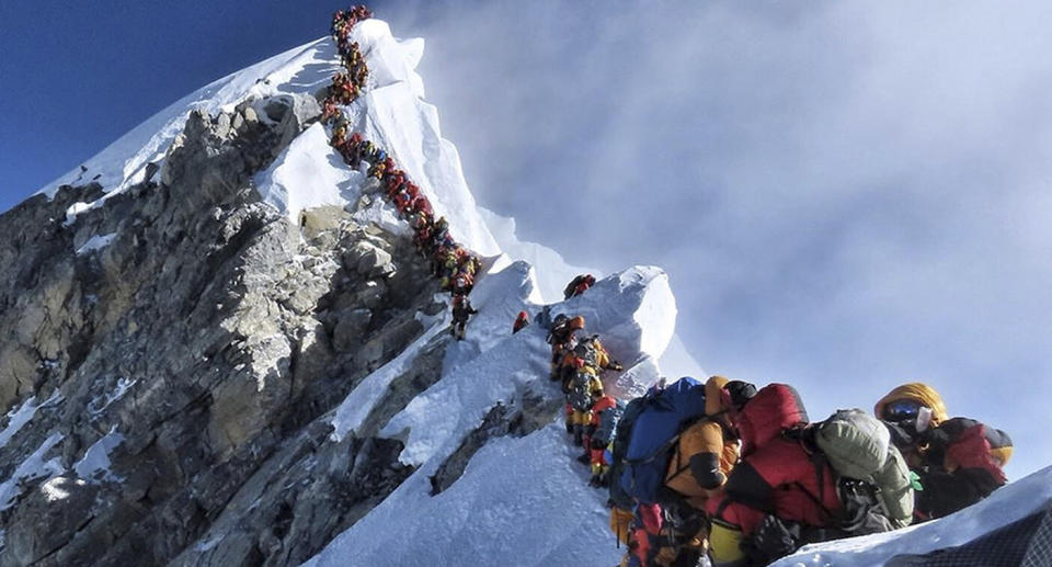 In this photo a long queue of mountain climbers line a path on Mount Everest.