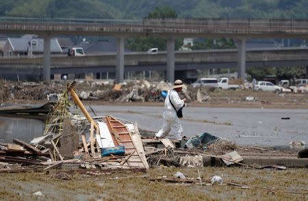A local resident walks in a flooded area in Mabi town in Kurashiki, Okayama Prefecture, Japan, July 13, 2018. REUTERS/Issei Kato