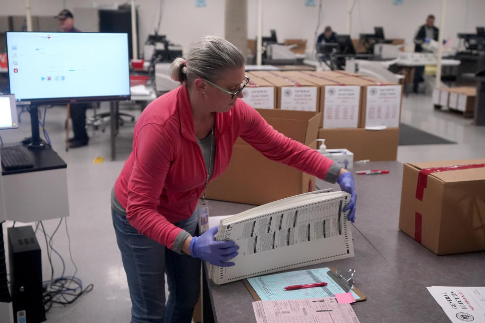 An election worker boxes tabulated ballots inside the Maricopa County Recorders Office, Wednesday, Nov. 9, 2022, in Phoenix. (AP Photo/Matt York)