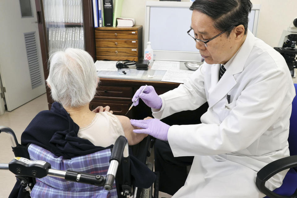 An elderly woman receives her first dose of Pfizer's COVID-19 vaccine at a special nursing home in Nagasaki, southwestern, Japan, Monday, April 12, 2021. Japan started its vaccination drive with medical workers and expanded Monday to older residents, with the first shots being given in about 120 selected places around the country. (Kyodo News via AP)