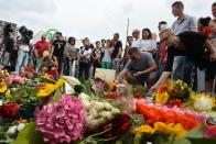 People lay flowers for the victims of the shooting near the Olympia-Einkaufszentrum shopping centre in Munich, southern Germany, on July 23, 2016, a day after the attack