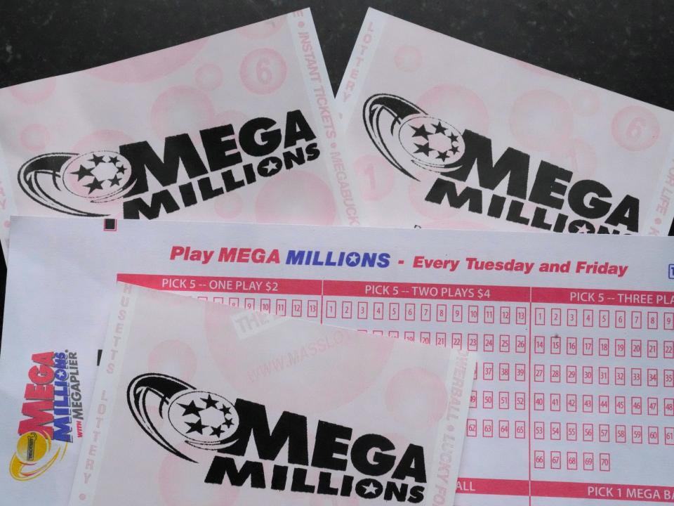 Mega Millions lottery tickets and a wager slip are displayed, Friday, Jan. 6, 2023, in Derry, N.H. An estimated $1.1 billion Mega Millions jackpot drawing Tuesday, Jan. 10, 2023, has people lined up at convenience stores nationwide to buy tickets in longshot hopes of winning a massive prize, but shop and gas station owners selling the tickets also have a chance at a big-figure bonus.