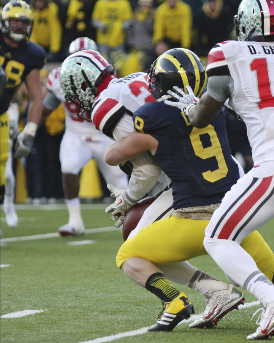 FILE - Ohio State defensive back Tyvis Powell, left, intercepts a pass intended for Michigan wide receiver Drew Dileo (9) on a 2-point conversion attempt in the closing minutes of an NCAA college football game in Ann Arbor, Mich., Nov. 30, 2103. The interception ensured the win for Ohio State. (AP Photo/Tony Ding, File)