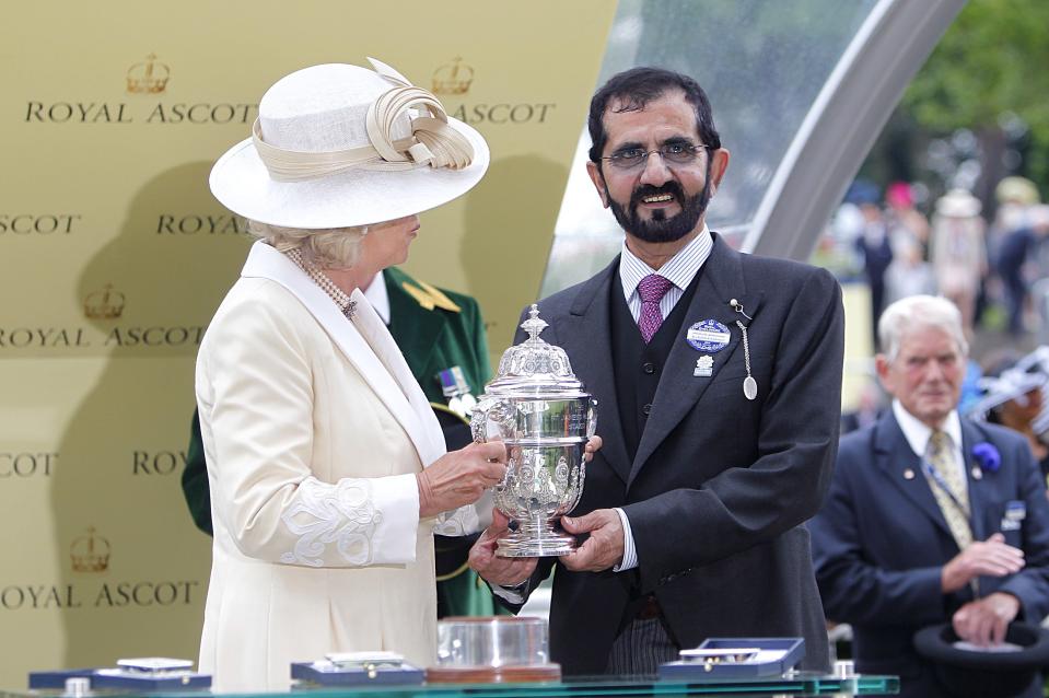 Mohammed bin Rashid Al Maktoum is presented with a trophy by The Duchess of Cornwall after his horse Dawn Approach won The St James's Palace Stakes