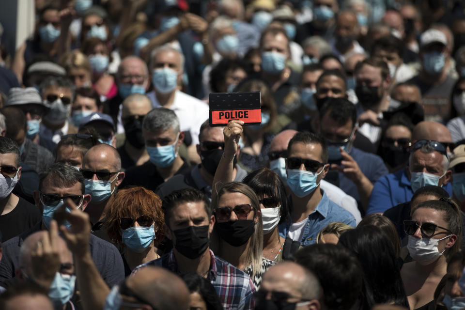 Police officers and civilians gather at a police station in Avignon, southern France, Sunday, May 9, 2021. Police officers and civilians gathered to commemorate the death of a police officer who was killed Wednesday at a known drug-dealing site in the southern France city of Avignon. (AP Photo/Daniel Cole)