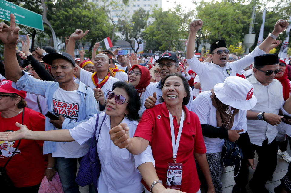 Supporters celebrate as they watch a live broadcast of the swearing-in ceremony of Indonesian President Joko Widodo in Jakarta, Indonesia, Sunday, Oct. 20, 2019. Indonesian President Joko Widodo, who rose from poverty and pledged to champion democracy, fight entrenched corruption and modernise the world's most populous Muslim-majority nation, was sworn in Sunday for his second and final five-year term with a pledge to take bolder actions. (AP Photo/Tatan Syuflana)