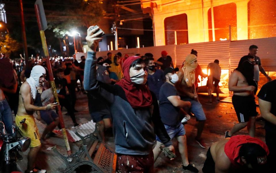 Stones are thrown at riot police during a protest against the government - Jorge Saenz/AP