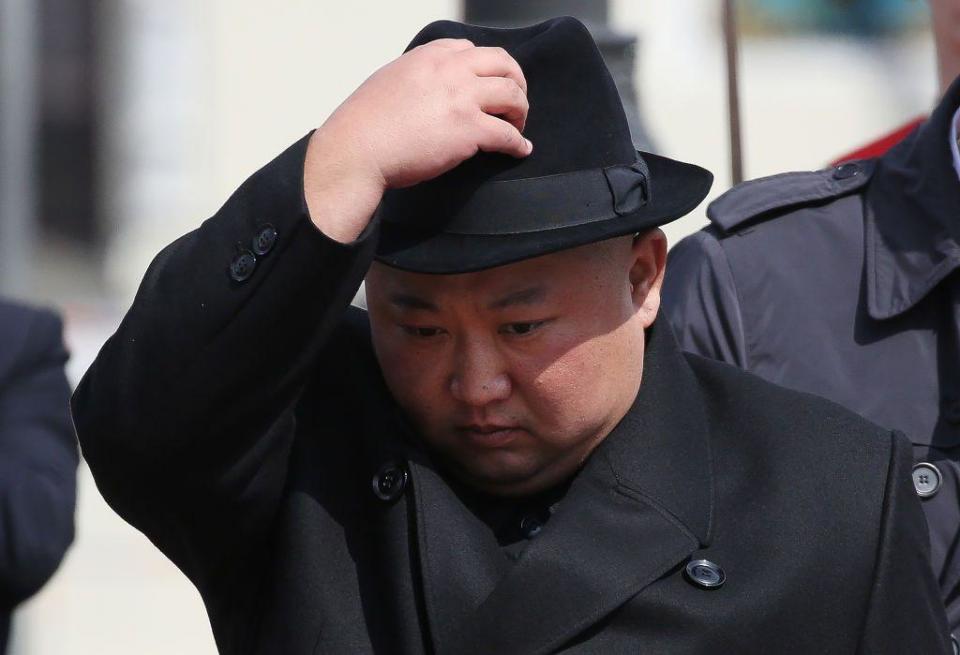 Kim Jong-un, vestido de negro y calándose un sombrero. 