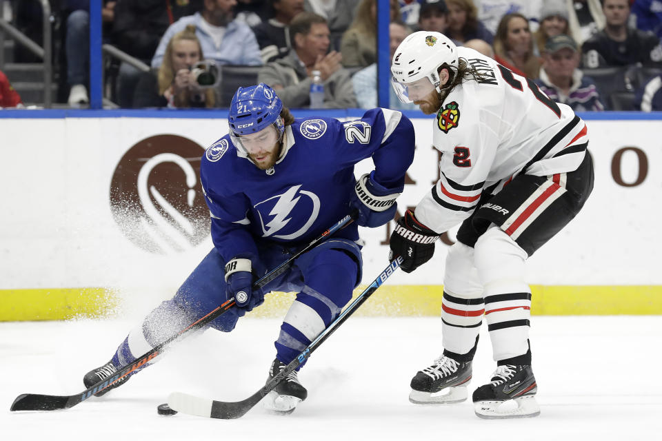 Tampa Bay Lightning center Brayden Point (21) tries to get around Chicago Blackhawks defenseman Duncan Keith (2) during the second period of an NHL hockey game Thursday, Feb. 27, 2020, in Tampa, Fla. (AP Photo/Chris O'Meara)