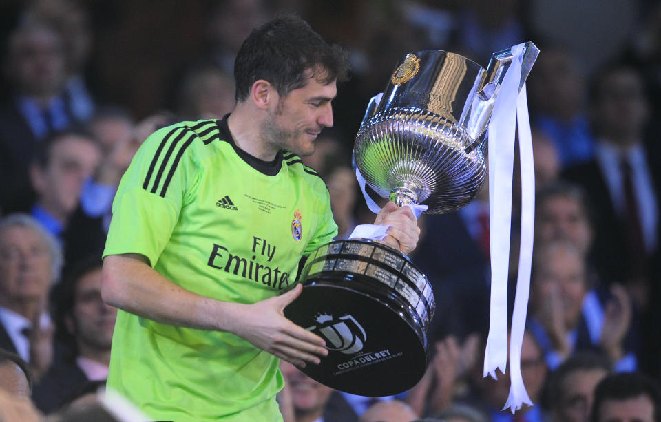 Real goalkeeper Iker Casillas holds the trophy at the end of the final of the Copa del Rey between FC Barcelona and Real Madrid at the Mestalla stadium in Valencia, Spain, Wednesday, April 16, 2014. Real defeated Barcelona 2-1. (AP Photo/Manu Fernandez)