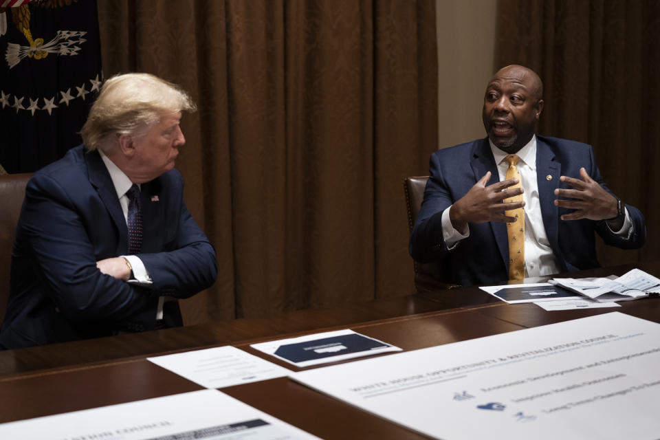 President Donald Trump listens as Sen. Tim Scott, R-S.C., speaks during a meeting on opportunity zones in the Cabinet Room of the White House, Monday, May 18, 2020, in Washington. (AP Photo/Evan Vucci)