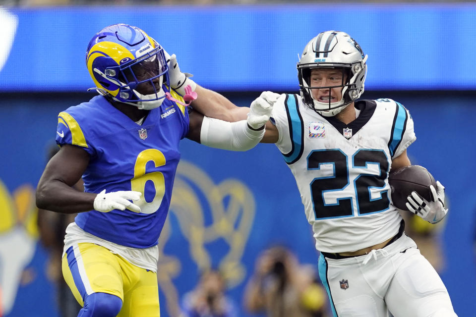 Carolina Panthers running back Christian McCaffrey (22) stiff-arms Los Angeles Rams cornerback Derion Kendrick (6) during the first half of an NFL football game Sunday, Oct. 16, 2022, in Inglewood, Calif. (AP Photo/Ashley Landis)