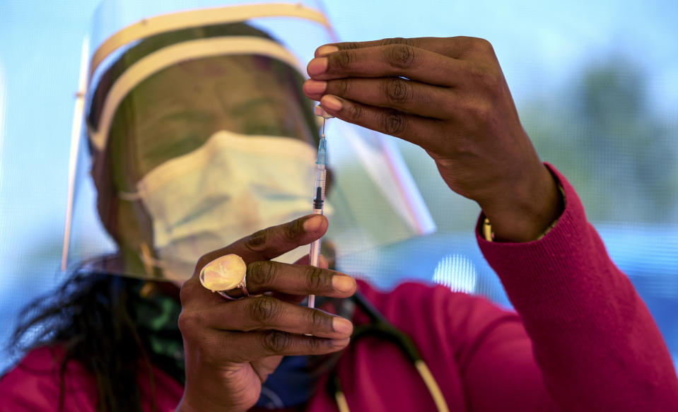 A health worker prepares a dose of the Pfizer coronavirus vaccine at the newly-opened mass vaccination program for the elderly at a drive-thru vaccination center outside Johannesburg, South Africa, Tuesday, May 25, 2021. South Africa aims to vaccinate 5 million of its older citizens by the end of June. (AP Photo/Themba Hadebe)