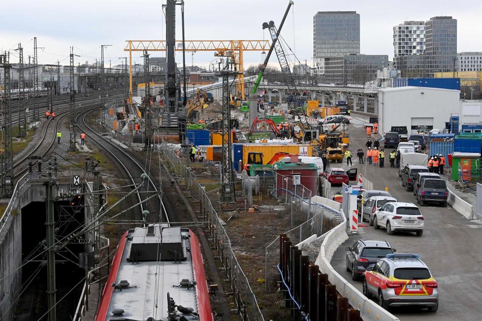 A regional train stands on the rails as fire brigades and policemen work at the site of a bomb explosion close to the main railway station in Munich, southern Germany, on December 1, 2021. - According to media reports, four persons were injured, one of them seriously, when a Word War II bomb exploded as works were under way at a construction site close to the railway station. (Photo by CHRISTOF STACHE / AFP) (Photo by CHRISTOF STACHE/AFP via Getty Images)