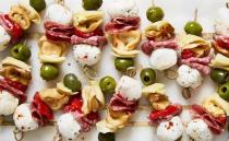 <p>Fresh tortellini makes this the hearty appetiser of our dreams. If you're not a fan of olives, pepperoncini peppers would be a delicious substitute! </p><p>Get the <a href="https://www.delish.com/uk/cooking/recipes/a35262428/antipasto-bites-recipe/" rel="nofollow noopener" target="_blank" data-ylk="slk:Antipasto Bites;elm:context_link;itc:0;sec:content-canvas" class="link ">Antipasto Bites</a> recipe.</p>