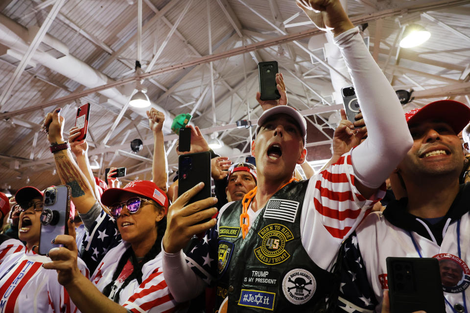 Supporters listen to former President Donald Trump speak at a campaign rally.