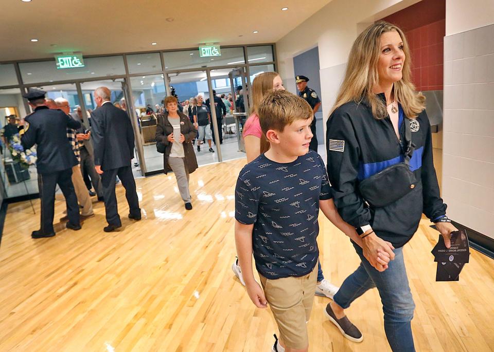 Cindy Chesna and her son, Jack, 9, and daughter Olivia, 14, walk into the Sgt. Michael Chesna Gymnasium at Chapman Middle School in Weymouth on Monday, Sept. 18, 2023.