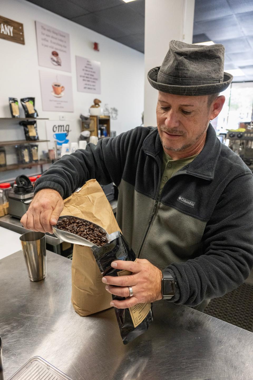 Owner Philip Brown bags up some of the signature roasted coffee beans at OMG Coffee in Mount Dora.