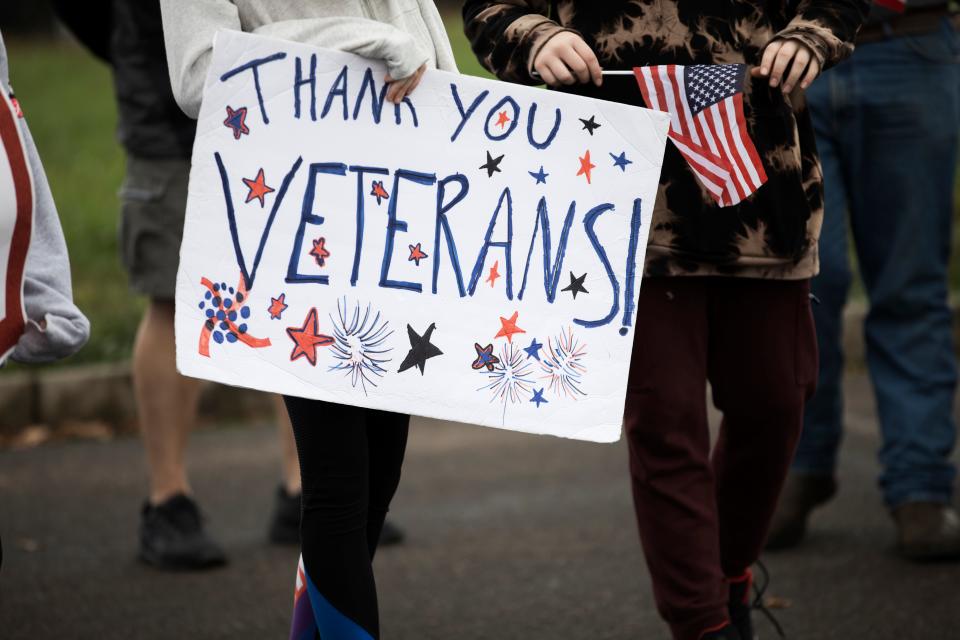 A parade attendee holds a sign during the 70th annual Veterans Day parade in Albany, Ore.