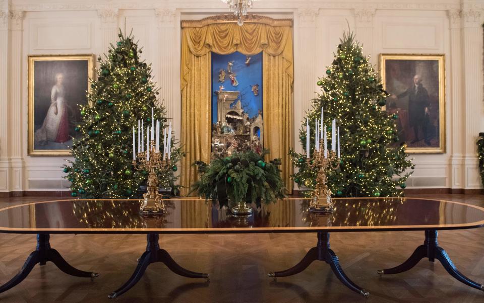 Christmas trees are seen during a preview of holiday decorations in the East Room of the White House in Washington, DC, November 27, 2017.