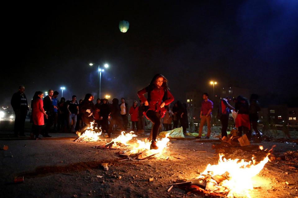 In this picture taken on Tuesday, March 18, 2014, an Iranian woman jumps over bonfires during a celebration, known as “Chaharshanbe Souri,” or Wednesday Feast, marking the eve of the last Wednesday of the solar Persian year, in Pardisan park, Tehran, Iran. The festival has been frowned upon by hard-liners since the 1979 Islamic revolution because they consider it a symbol of Zoroastrianism, one of Iran’s ancient religions of Iranians. They say it goes against Islamic traditions. (AP Photo/Ebrahim Noroozi)