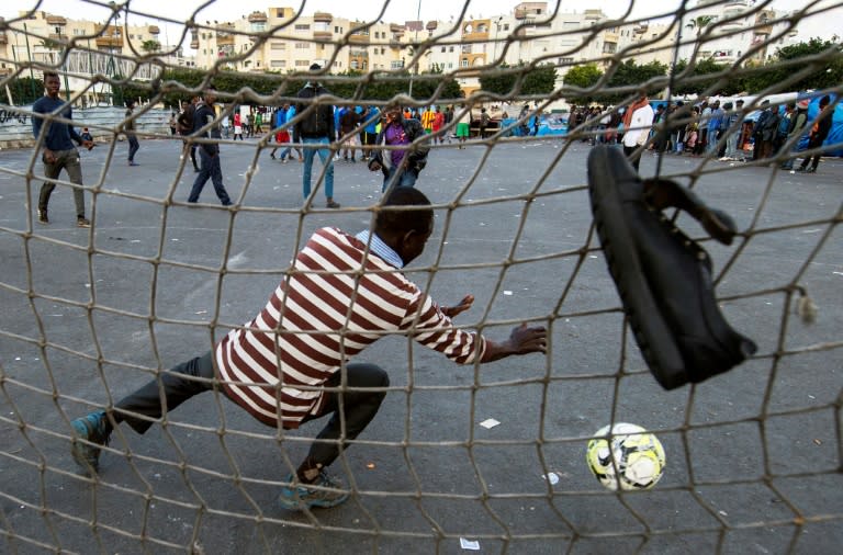 Sub-Saharan migrants play football on a makeshift pitch at the Oulad Ziane migrant camp in Morocco's Casablanca on February 19, 2018
