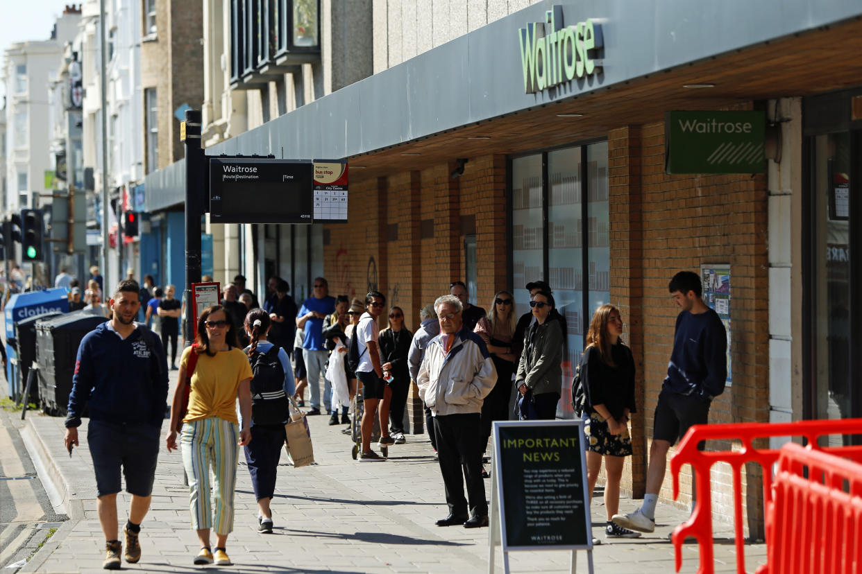 A long queue of people wait outside of Waitrose in Brighton as the UK continues in lockdown to help curb the spread of the coronavirus.