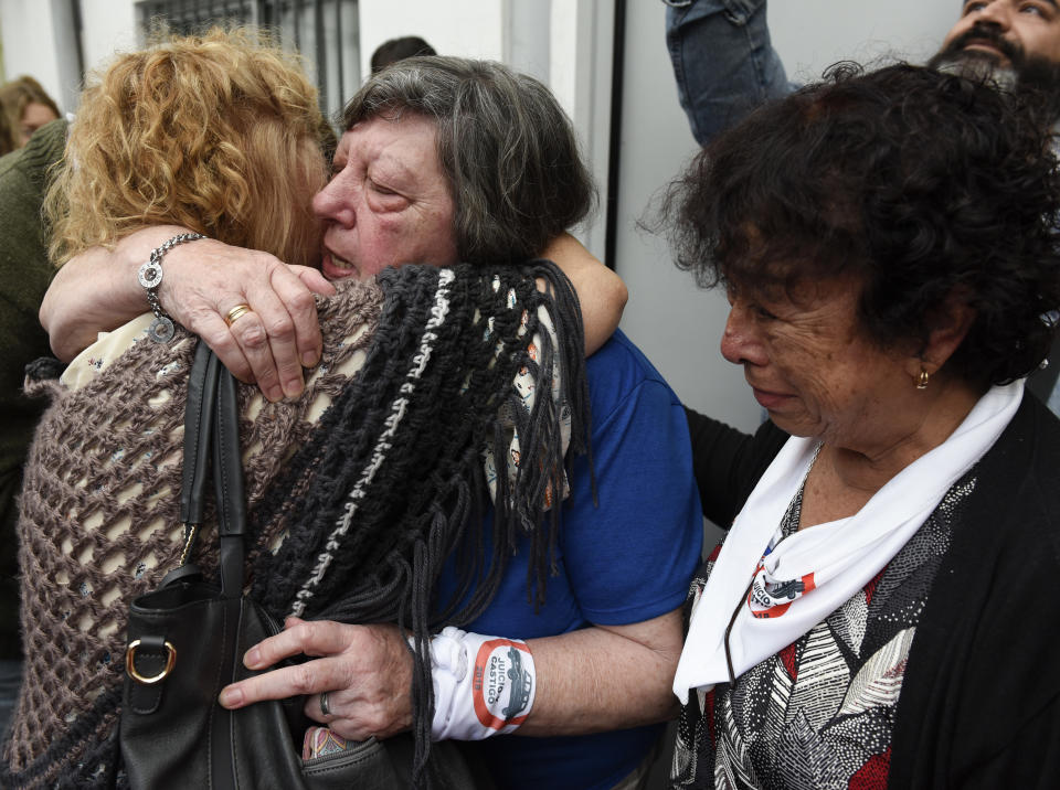 Family members of ex-Ford Motor Co. employees embrace at the end of a sentencing hearing for two former Ford Motor Co. executives charged with crimes against humanity for allegedly targeting Argentine union workers for kidnapping and torture after the country's 1976 military coup, in Buenos Aires, Argentina, Tuesday, Dec. 11, 2018. The court sentenced to prison factory manufacturing director Pedro Muller and security manager Hector Francisco Sibilla, for helping agents of the country's former dictatorship round up Argentine union workers who were tortured and held in military jails. (AP Photo/Gustavo Garello)