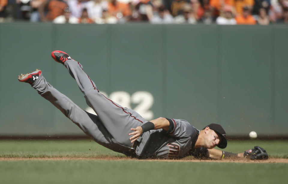 Arizona Diamondbacks third baseman Jake Lamb dives for a ground ball hit by the San Francisco Giants' Jarrett Parker in the sixth inning of a baseball game Monday, April 10, 2017, in San Francisco. Parker got a single on the play. (AP Photo/Eric Risberg)