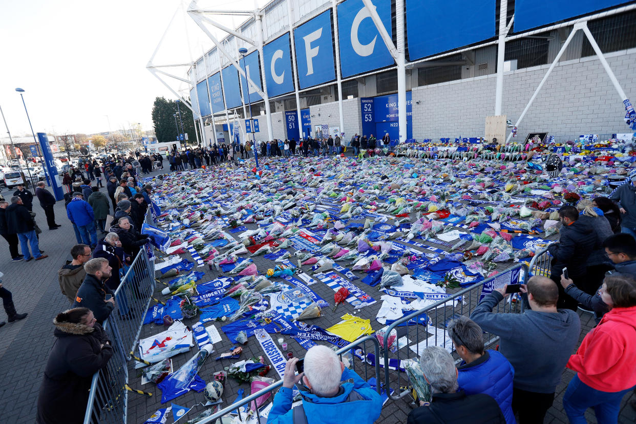 People look at tributes left outside Leicester City's King Power stadium, after the club's owner Thai businessman Vichai Srivaddhanaprabha and four other people died when the helicopter they were travelling in crashed as it left the ground after the match on Saturday, in Leicester, Britain, October 29, 2018. REUTERS/Peter Nicholls