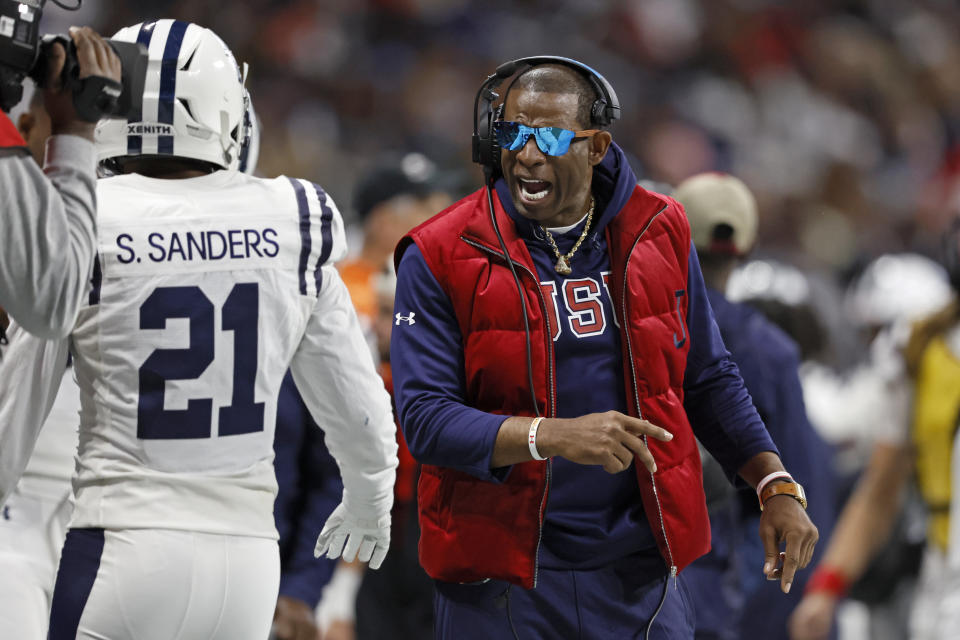 Jackson State head coach Deion Sanders talks with safety Shilo Sanders (21) during the first half against the North Carolina Central in the Celebration Bowl NCAA college football game, Saturday, Dec. 17, 2022, in Atlanta.(Jason Getz/Atlanta Journal-Constitution via AP)