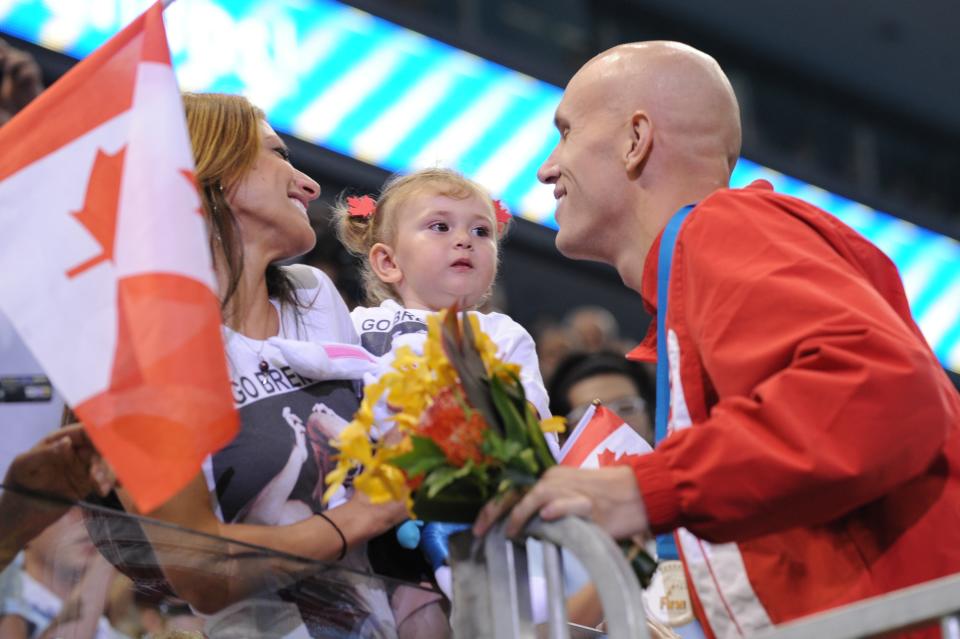 CHANGING RELATION OF NIECE Canada's Brent Hayden (R) greets his fiance Nadina Zarifeh and her niece Nessa after he won silver in the final of the men's 100-metre freestyle swimming event in the FINA World Championships at the indoor stadium of the Oriental Sports Center in Shanghai on July 28, 2011. AFP PHOTO / PETER PARKS (Photo credit should read PETER PARKS/AFP/Getty Images)