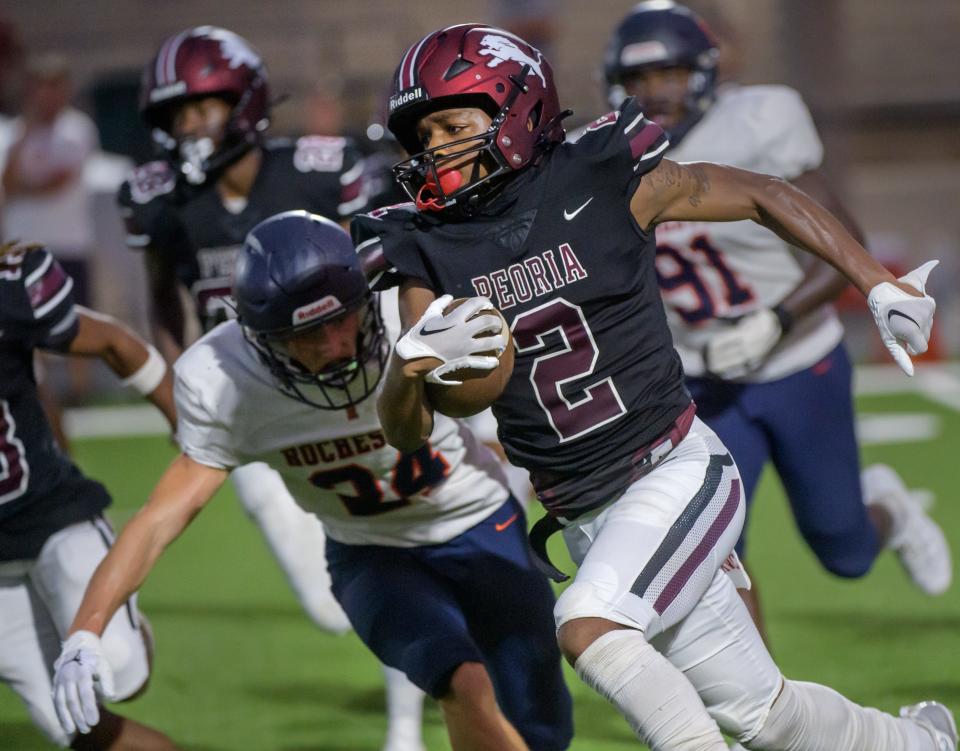 Rochester's Ty Durocher chases Peoria High's TQ Webb in the first half of their opening night football game Friday, Aug. 25, 2023 at Peoria Stadium.