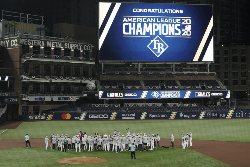 Tampa Bay Rays stand at midfield to receive the American League championship trophy following their victory against the Houston Astros in Game 7 of a baseball American League Championship Series, Saturday, Oct. 17, 2020, in San Diego. The Rays defeated the Astros 4-2 to win the series 4-3 games. (AP Photo/Ashley Landis)