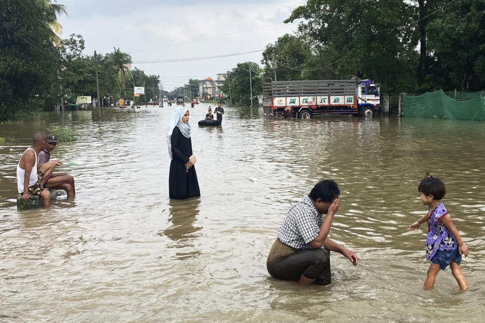 Local residents wade through a flooded road in Bago, Myanmar, about 80 kilometers (50 miles) northeast of Yangon, Friday, Aug. 11, 2023. (AP Photo)