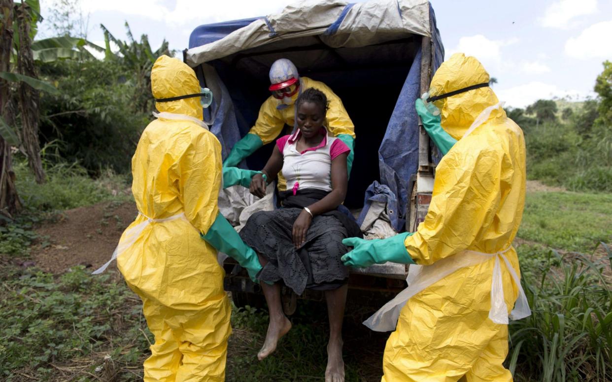 Health workers take a patient to a treatment centre during the 2014 Ebola epidemic in Liberia - AFP