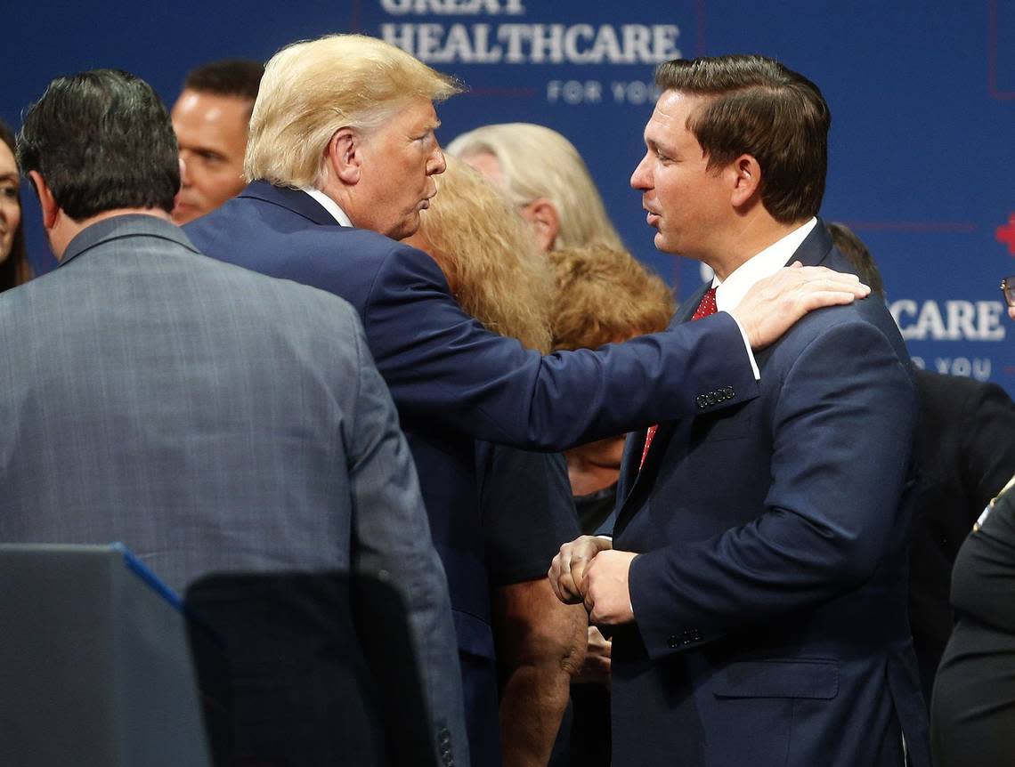 In 2019, then-President Donald Trump talks to Florida Gov. Ron DeSantis after giving a speech to his supporters at the Sharon L. Morse Performing Arts Center in The Villages, Fla.