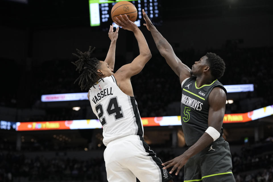 Minnesota Timberwolves guard Anthony Edwards (5) goes up to block a shot attempt by San Antonio Spurs guard Devin Vassell (24) during the second half of an NBA basketball game Wednesday, Dec. 6, 2023, in Minneapolis. (AP Photo/Abbie Parr)