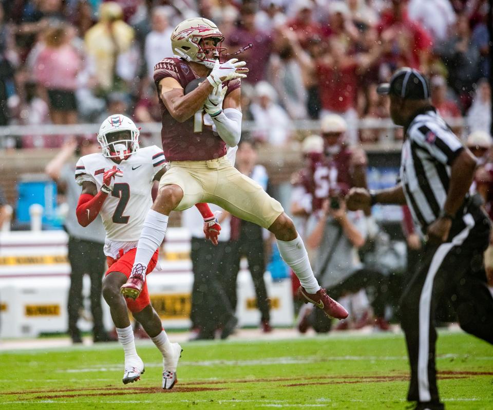 Florida State wide receiver Johnny Wilson (14) jumps in the air to catch a pass. The Florida State Seminoles hosted the Duquesne Dukes at Doak Campbell Stadium on Saturday, Aug. 27, 2022.