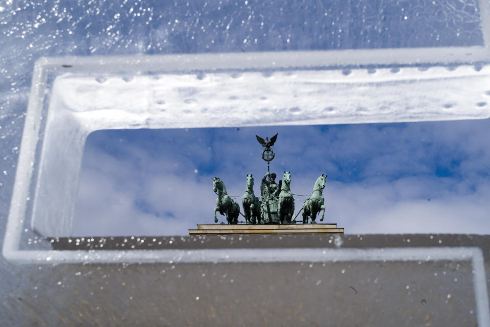 The Brandenburg Gate stands behind an ice block set up by Climate activists in Berlin, Germany, Tuesday, May 14, 2019. The ice block is part of a slogan reading 'Last Exit' set up by Greenpeace in front of the Brandenburg Gate as a protest in reference to the 'Petersberg climate talks'. (AP Photo/Markus Schreiber)