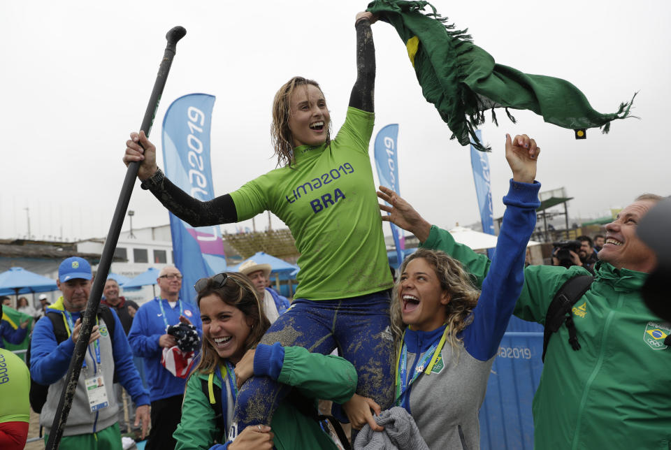 Brazil's Lena Guimaraes celebrates after winning the gold medal in the women's SUP race final during the Pan American Games on Punta Rocas beach in Lima Peru, Friday, Aug.2, 2019. (AP Photo/Silvia Izquierdo)