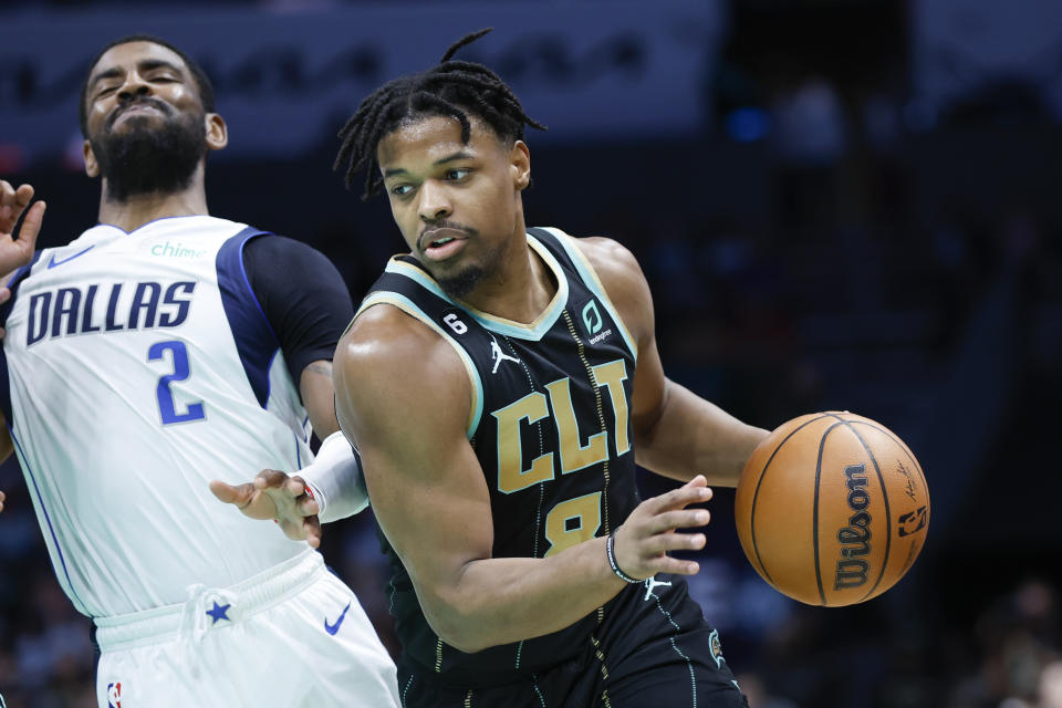 Charlotte Hornets guard Dennis Smith Jr., right, drives around Dallas Mavericks guard Kyrie Irving (2) during the first half of an NBA basketball game in Charlotte, N.C., Sunday, March 26, 2023. (AP Photo/Nell Redmond)