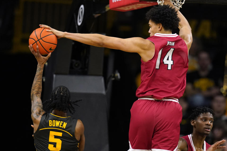 Northern Illinois forward Yanic Konan Niederhauser (14) blocks a shot by Iowa guard Dasonte Bowen (5) during the first half of an NCAA college basketball game, Friday, Dec. 29, 2023, in Iowa City, Iowa. (AP Photo/Charlie Neibergall)