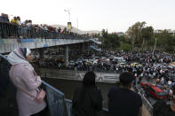 FILE - Dozens of Syrians wait at the President's Bridge in Damascus for relatives they hope would be among those released from prison on Tuesday, May 3, 2022, on the second day of the Fitr holiday. A newly released video taken in 2013 showed blindfolded men who were thrown into a large pit and shot dead by Syrian agents, who then set the bodies on fire. The video stirs new fears over the fate of tens of thousands who went missing during Syria's long-running conflict and serves as a grim reminder of the war's unpunished massacres, just as similar atrocities take place in Ukraine. (AP Photo/Omar Sanadiki, File)