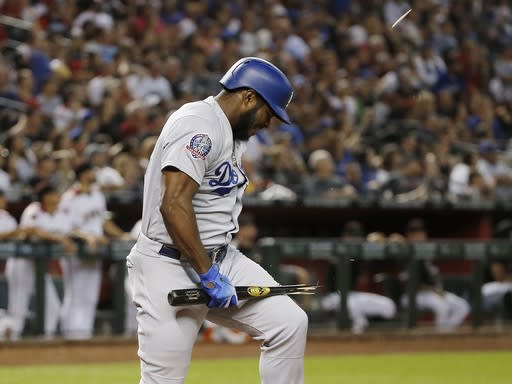 Los Angeles Dodgers’ Yasiel Puig breaks his bat over his leg after flying out against the Arizona Diamondbacks during the fifth inning of a baseball game Wednesday, Sept. 26, 2018, in Phoenix. (AP Photo/Ross D. Franklin)