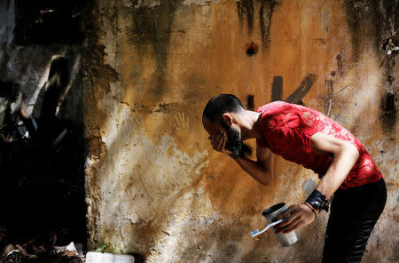 Rodrigo, 26, who is among members of lesbian, gay, bisexual and transgender (LGBT) community, that have been invited to live in a building that the roofless movement has occupied, washes his face, in downtown Sao Paulo, Brazil, November 16, 2016. REUTERS/Nacho Doce