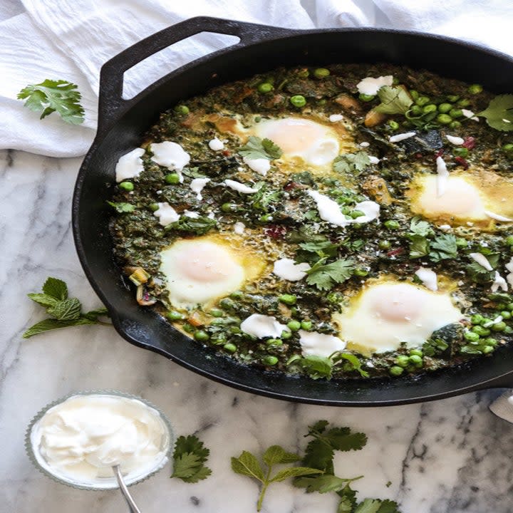 Green shakshuka in a skillet.